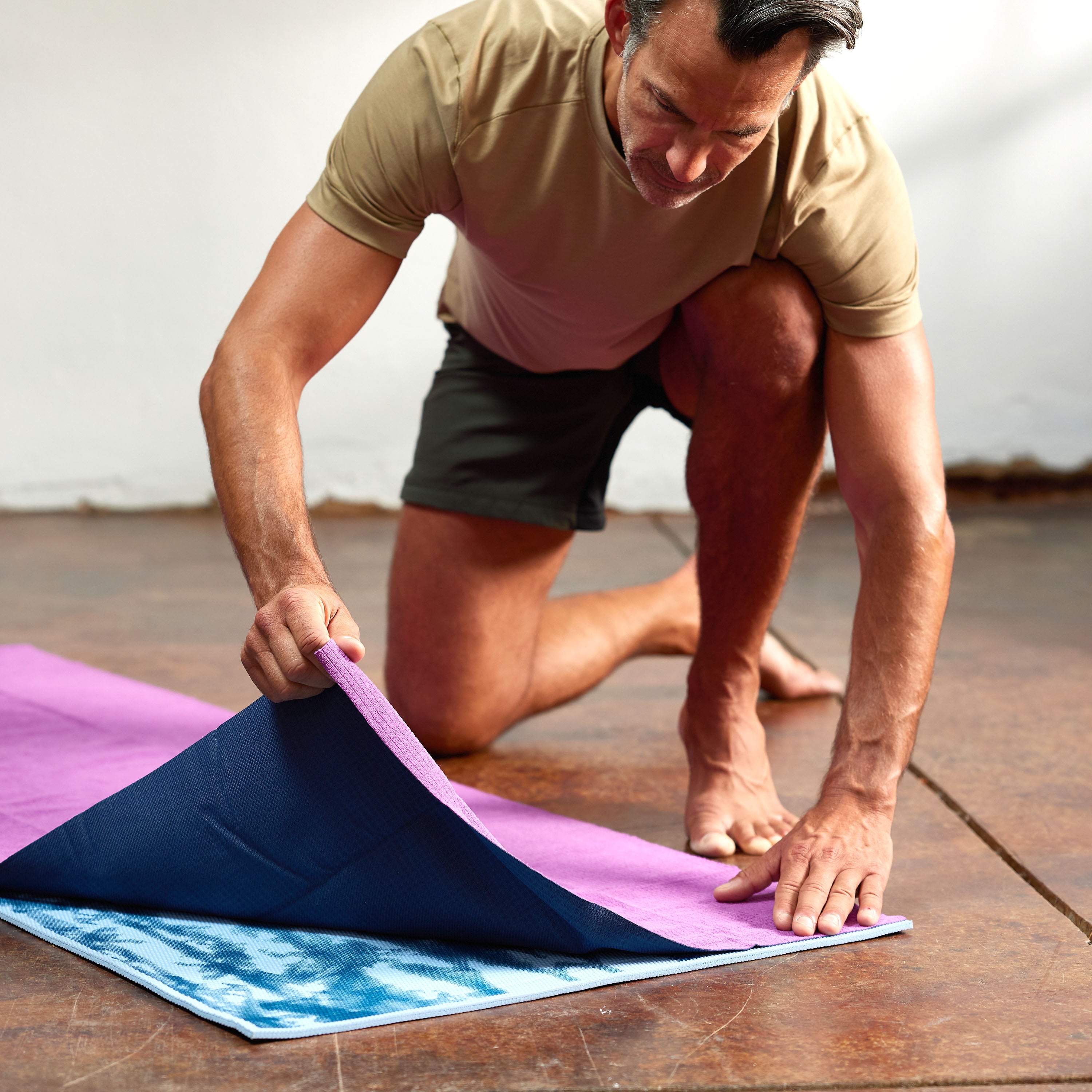 Person placing the No-Slip Towel on top of yoga mat